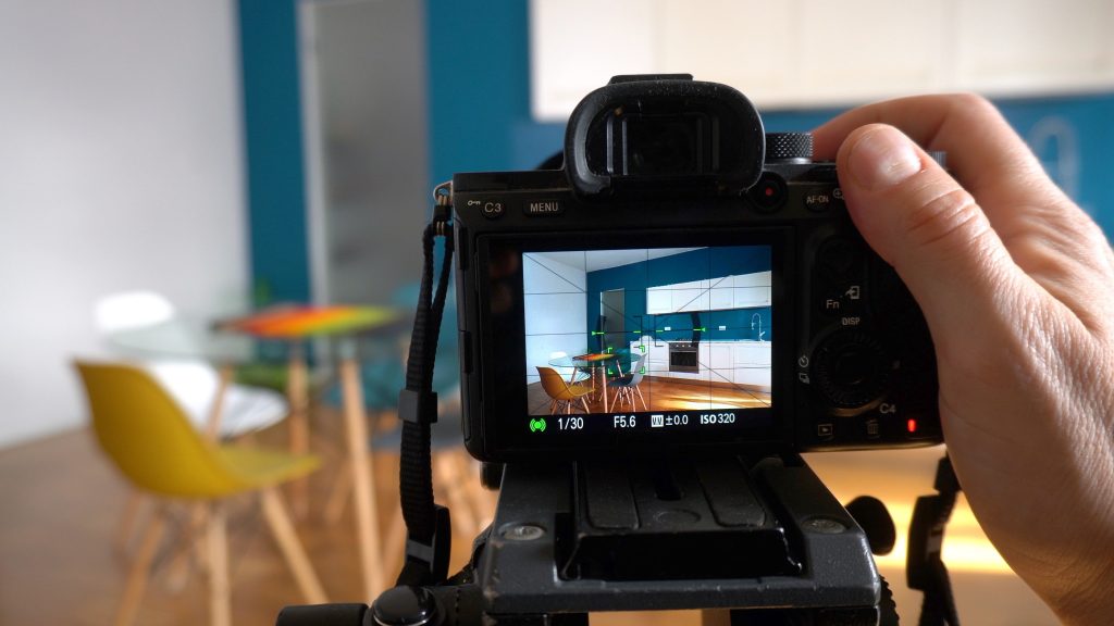 Real estate photographer taking pictures and videos  at house  in apartment living room with professional camera - selling home with real estate agency and home staging indoor home design