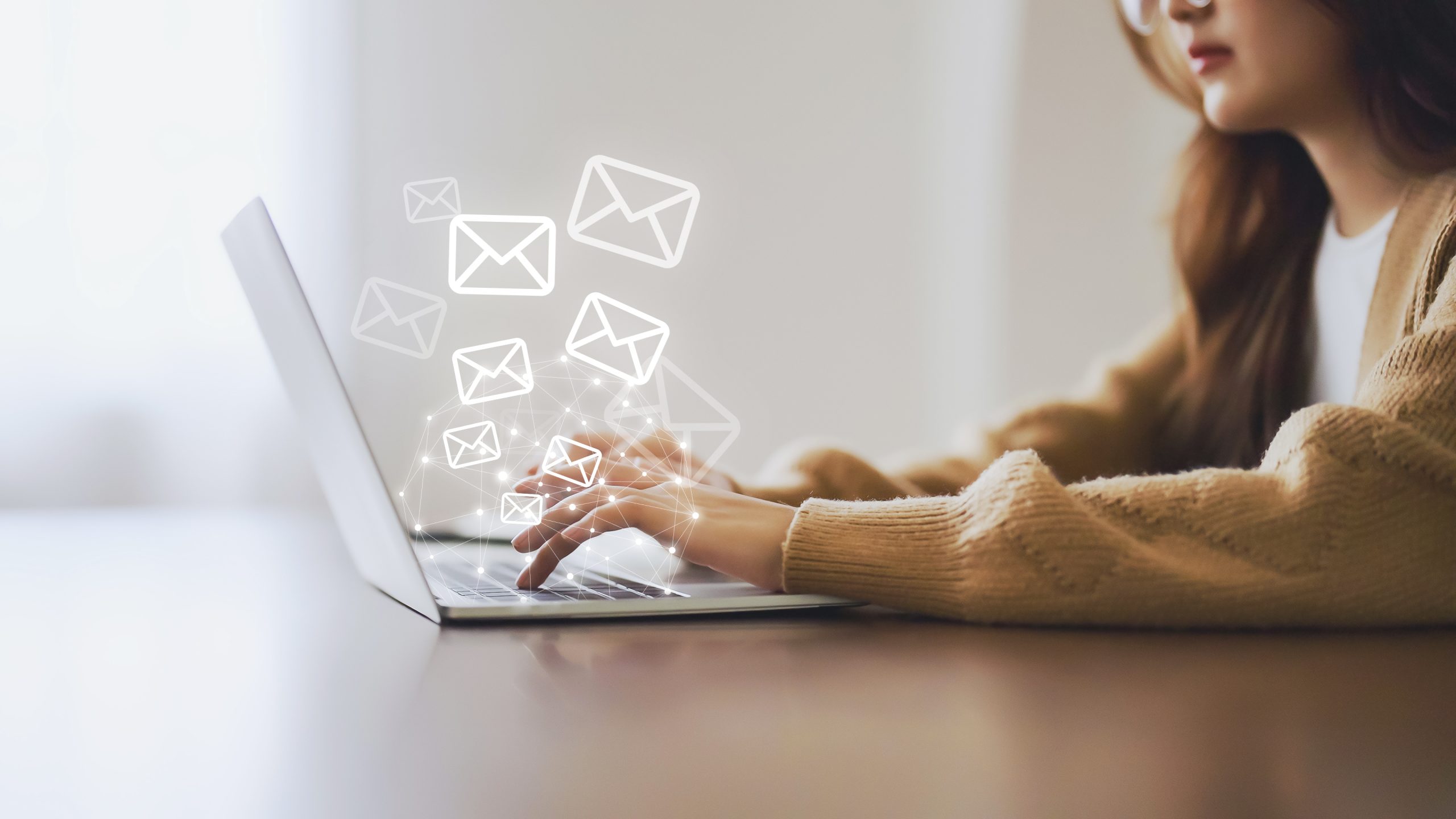 Woman using computer laptop and sending online message with email icon.